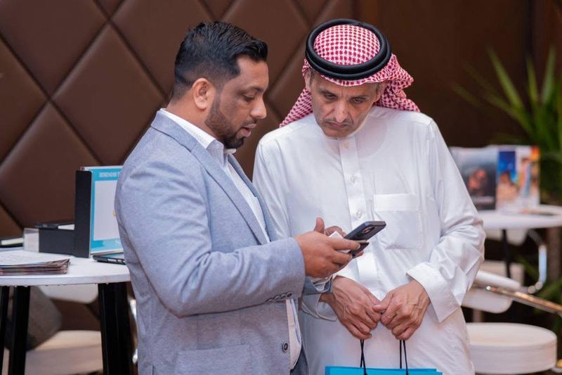 A Serendib representative and a partner looking at a phone together