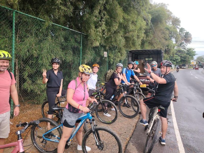 Guests in helmets on mountain bikes at the roadside