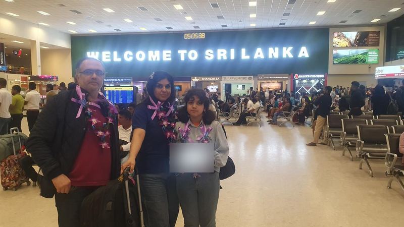A family with orchid garlands in the arrivals hall