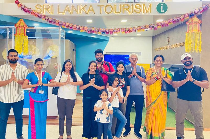 A family group greeting with joined hands at the festively decorated tourism desk