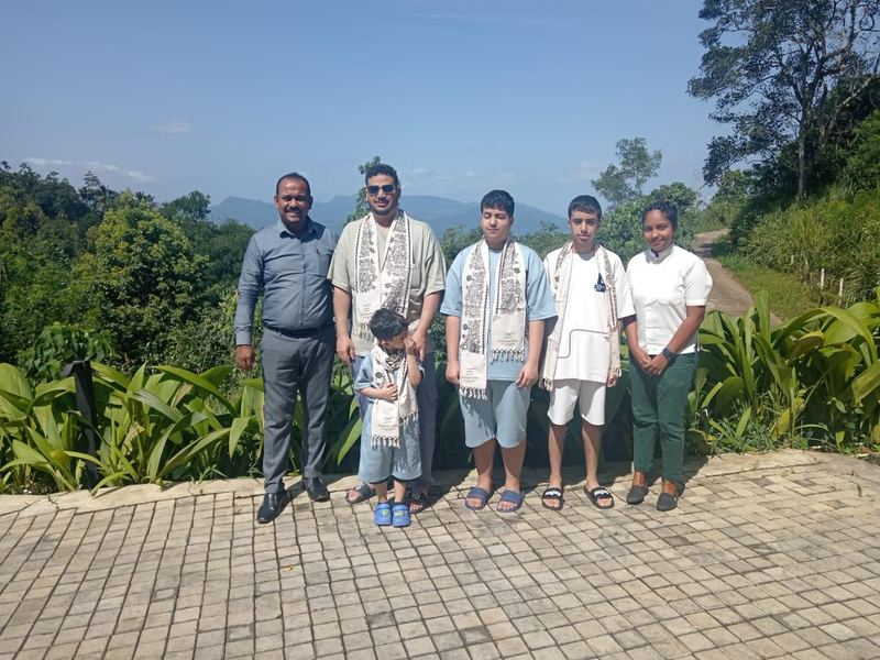 A family at a viewpoint with green hills behind