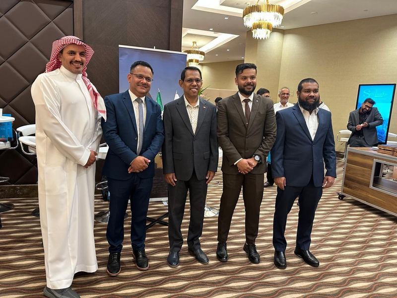 Serendib representatives standing with a partner at a roadshow