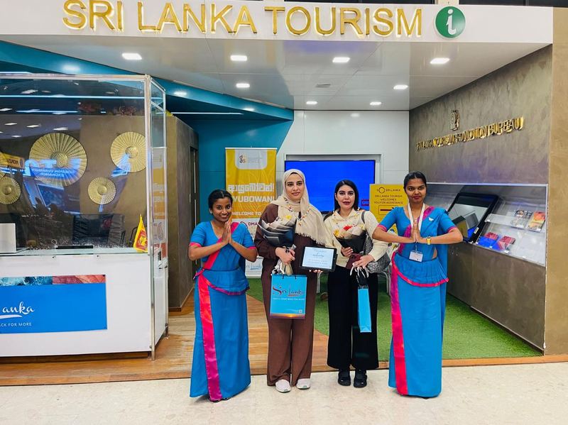 Guests with gift bags between hostesses at the tourism desk